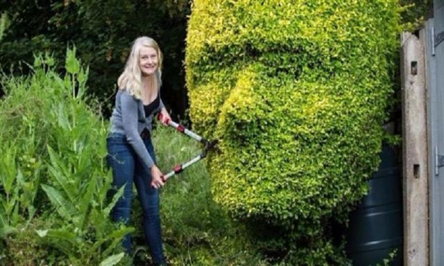 بريطانية تحول حديقة بيتها لمعرض فني بعد نحت وجوه زوجها وابنها علي أشجار الحديقة