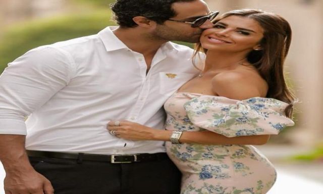 صور.. كريم فهمي يهدي زوجته قبلة رومانسية في عيد ميلادها