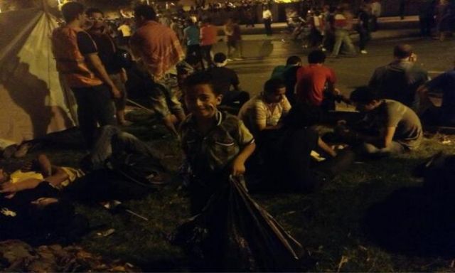 طفل يجمع القمامة فى ميدان التحرير ويعلق: الثورة مستمرة